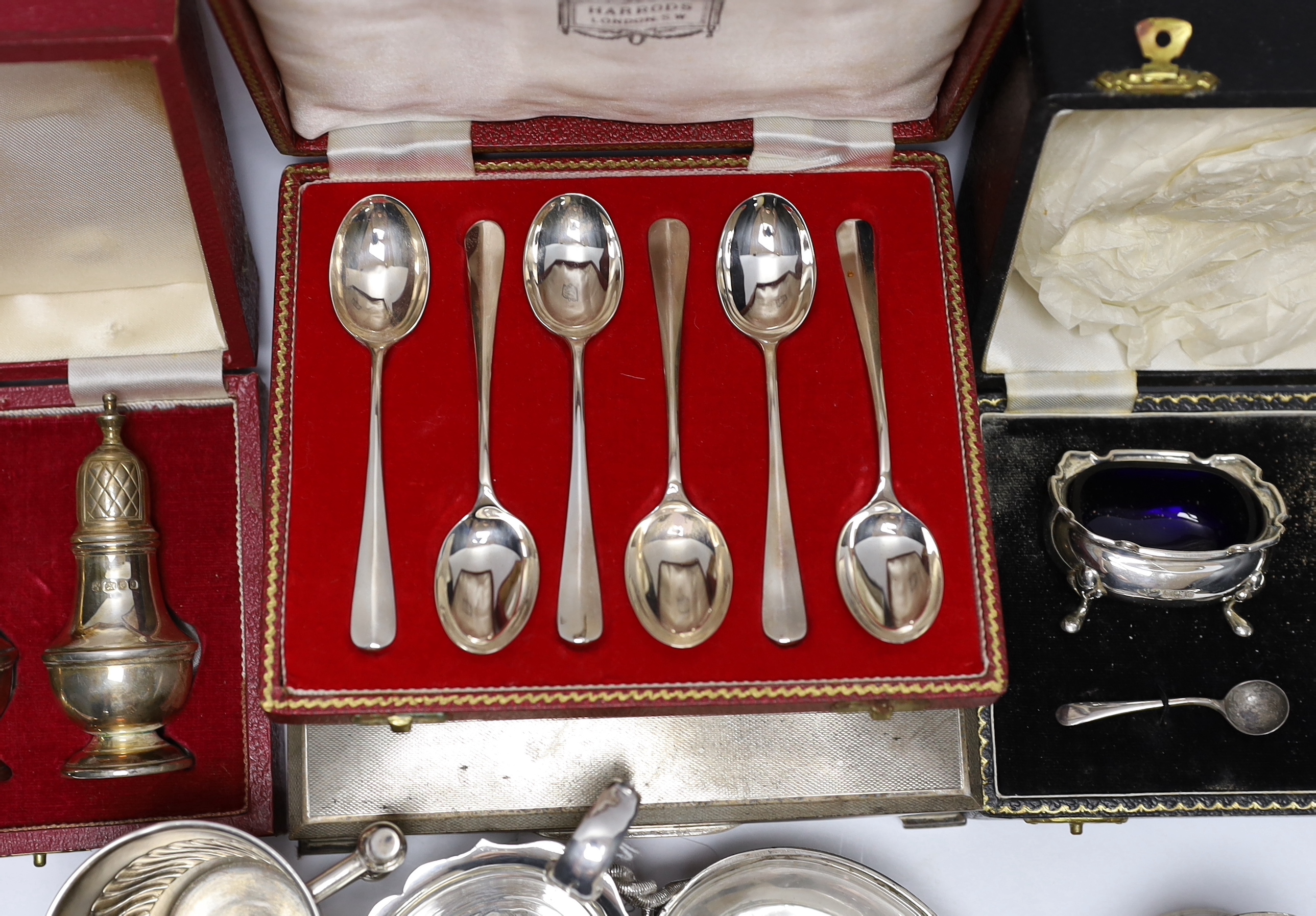 Sundry silver wares including a cigarette box and case, cased condiment set, cased pair of pepperettes and cased set of six teaspoons, sauceboat, Victorian mustard, Victorian mug with angular handle, nine items of flatwa